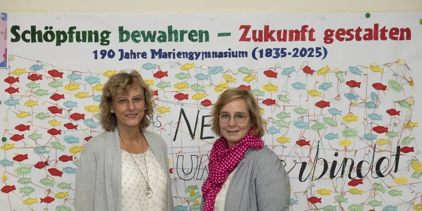 Dorothea Reininger und Kirsten Griep-Raming vor der Schulpastoralwand zum 190-jährigen Schuljubiläum